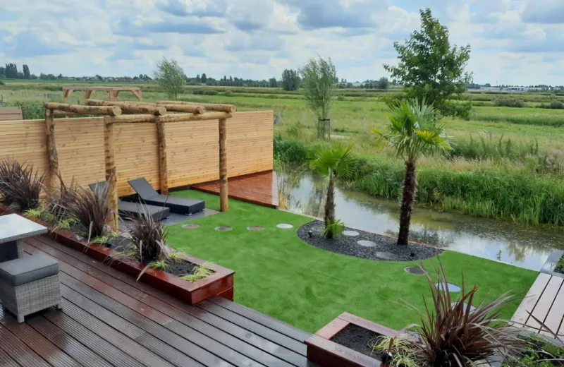 Ontworpen tuin met vlonder, pergola en beplanting aan het water