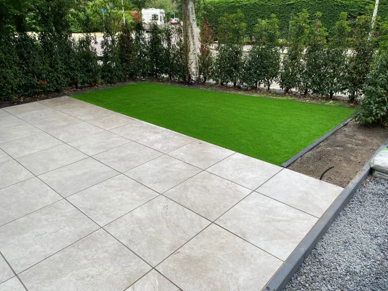 Voortuin met keramische tegels, kunstgras en antracieten opsluitbanden